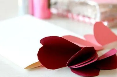 Bạn cắt tầm 8-10 trái tim, càng nhiều trái tim thì cánh hoa trái tim càng đẹp hơn, tuy nhiên, tùy theo kích cỡ của chiếc thiệp hoa rồi bạn ước lượng số trái tim giấy cần cắt nhé!