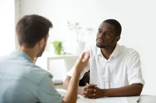 A person listens closely to a colleague.